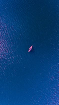 an aerial view of a person in the water with a surfboard