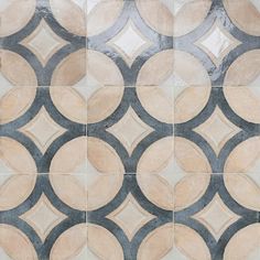 an artistic tile design with circles and rings in grey, beige and white colors on the floor