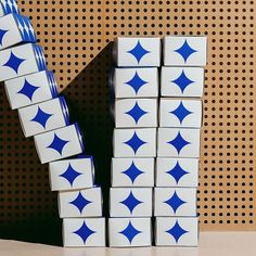 several stacks of blue and white tiles stacked on top of each other in front of a polka dot wall