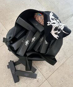 a pile of black luggage sitting on top of a tiled floor next to a pair of scissors