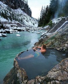 a woman is swimming in a hot spring