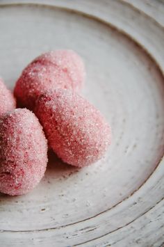 three powdered donuts sitting on top of a white plate