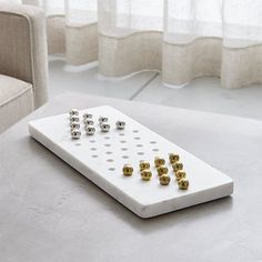 a remote control sitting on top of a white table next to a beige chair and window