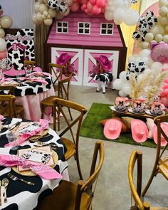 a decorated party with pink, black and white balloons in the shape of a barn