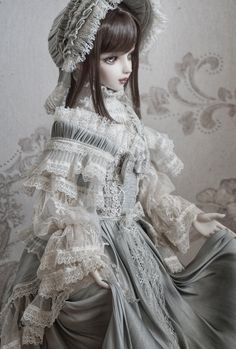 a doll is wearing a dress and bonnet