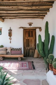 a house with cactus plants in front of it and a wooden door on the side