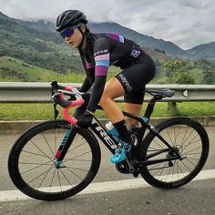 a woman riding a bike down the road