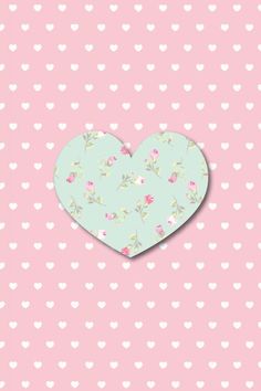 a paper heart on a pink background with white hearts and polka dotes in the background