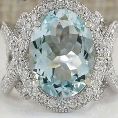 an oval blue topazte surrounded by white diamonds in a diamond halo style ring