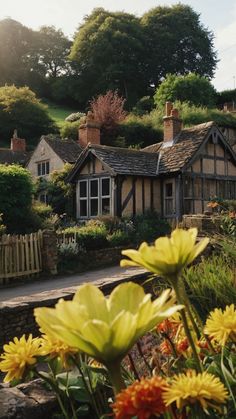 the sun shines brightly on some flowers in front of a small house and garden