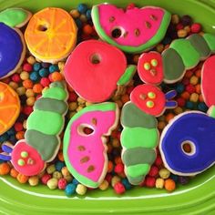 there are many different decorated cookies in the bowl on the table, including one that looks like caterpillars