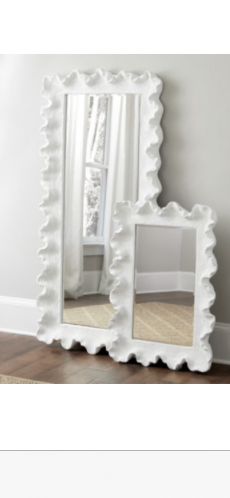 a white mirror sitting on top of a wooden floor