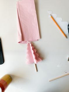 a white table topped with pink napkins next to a phone and other office supplies