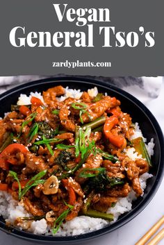 a black bowl filled with meat and vegetables on top of rice next to chopsticks