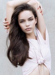 a woman with long hair posing for the camera