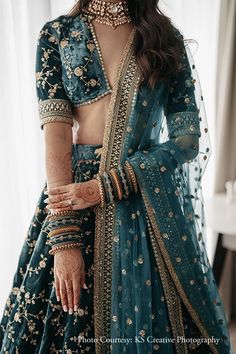 a woman wearing a blue lehenga and jewelry