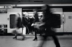 black and white photograph of people exiting a subway train