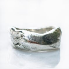 a close up of a silver ring on a white surface