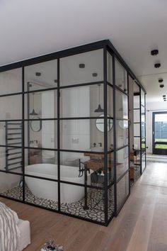 a large bathroom with glass walls and wooden floors