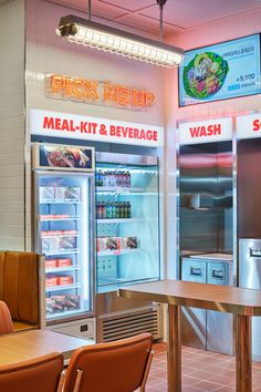 the inside of a fast food restaurant with refrigerators and tables in front of it