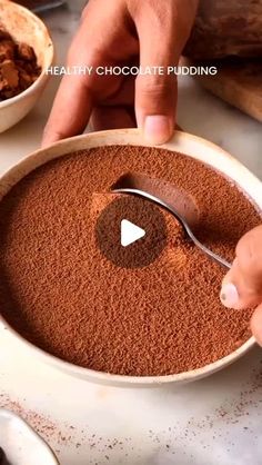 a person scooping cocoa into a bowl