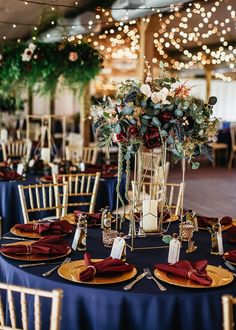 the tables are set with gold chargers and blue linens for an elegant wedding reception