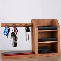 a wooden shelf with keys and remotes hanging from it