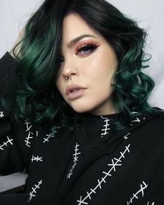 a woman with green hair is posing for the camera