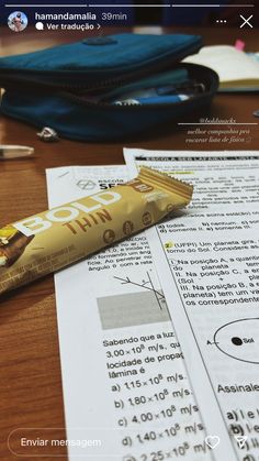 a chocolate bar sitting on top of a wooden table next to a pen and paper