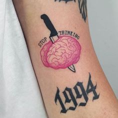 a person with a knife and brain tattoo on their arm