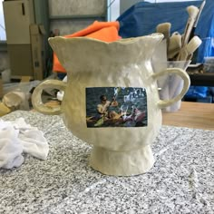 a white vase sitting on top of a counter