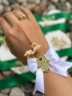 a woman's hand wearing a bracelet with flowers on it