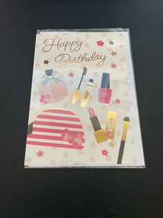 a birthday card with makeup and nail polish on it, sitting on top of a table