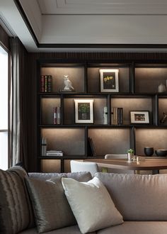 a living room filled with lots of furniture and bookshelves