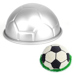 a cake that is shaped like a soccer ball and next to a dome on a white background