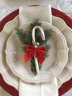 a white plate topped with candy canes and a christmas decoration on top of it