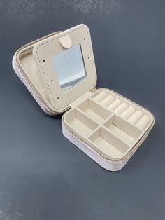 an open white case with multiple compartments on the top and bottom, sitting on a gray surface