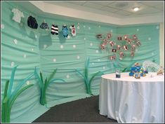 a baby shower themed room with clothes hanging on the wall and decorations in front of it