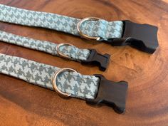 two blue and black leashes with metal rings on a wooden table, close up