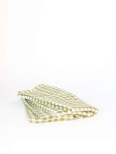 two green and white checkered cloths on top of each other, one folded up