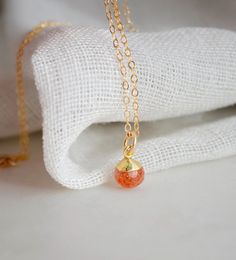 Tiny Genuine Sunstone Necklace in 14k Gold Filled Dazzle your neckline with this petite twinkling sunstone pendant!  First discovered in Norway, Sunstone gets its shimmering nature from tiny pieces of Hematite. This gem is believed to carry the uplifting energy of the sun, and is perfect for those who are stuck in a rut or need a little reminder to live and enjoy life. It is a stone of empowerment that helps your true self shine, while encouraging joy, passion, and good fortune. This necklace is Minimalist Amber Round Pendant Jewelry, Minimalist Orange Necklace As Gift, Minimalist Orange Jewelry For Gifts, Sunstone Jewelry, Layering Jewelry, In A Rut, Pendant Minimalist, Stuck In A Rut, Raw Crystal Jewelry