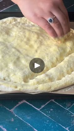 a person is making an uncooked pizza dough