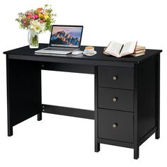 a laptop computer sitting on top of a wooden desk next to a vase with flowers