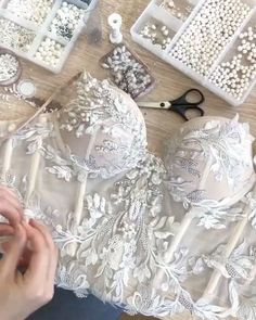 the woman is making beaded bras on the table