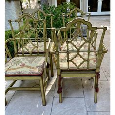 four green bamboo chairs sitting on top of a tile floor