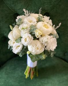 a bouquet of white flowers sitting on top of a green chair