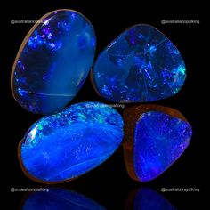 three blue stones sitting on top of a black surface next to each other with different colors