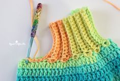 a crocheted piece of cloth next to a knitting needle