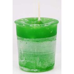 a green candle with a stick sticking out of it's top in front of a white background