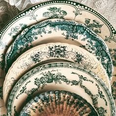 green and white plates stacked on top of each other in an ornate pattern with lace